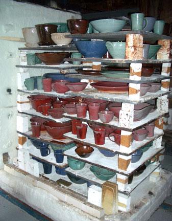 After the firing and he kiln has cooled, the kiln is opened and the copper red pots are now visible.